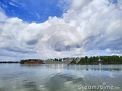 bauxite barge tied on a riverside tree with trees and blue sky background Stock Photo