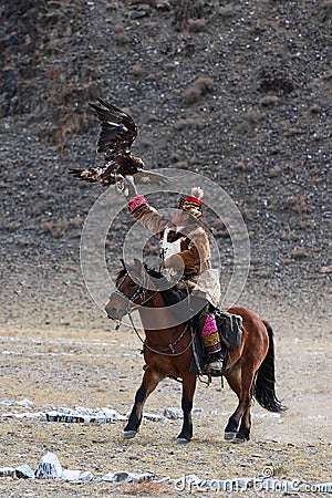 Unknown huntsman with Golden Eagle shows his experience in falconry. Editorial Stock Photo