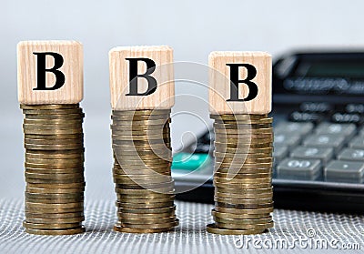 BBB - acronym on wooden cubes on the background of coins and calculator Stock Photo