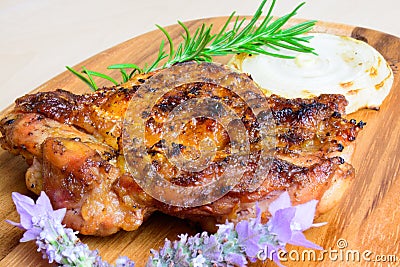 Bbq grilled boneless chicken thigh with onion slice and with rosemary and lavender garnish Stock Photo