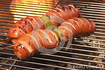 BBQ Spit Roasted Fatty Sausage On The Hot Flaming Grill Stock Photo