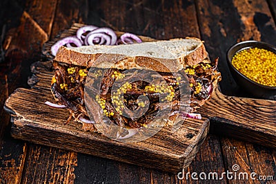BBQ Texas Sandwich with slow roasted brisket beef meat. Dark wooden background. Top view Stock Photo