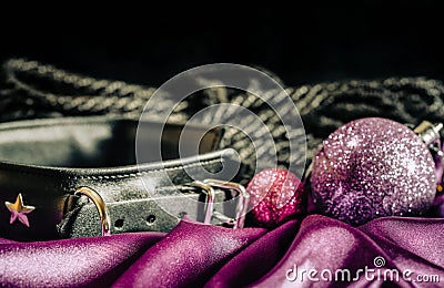 bdsm still life leather collar shibari rope and christmas ball on pink cloth close up Stock Photo