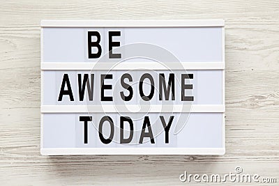 `Be awesome today` word on lightbox over white wooden background, from above. Stock Photo