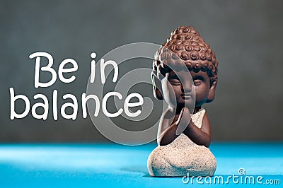 Be in Balance - motivation for balancing between life, work, family, sport and yoga. Meditating babby Buddha Stock Photo