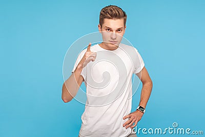 Be careful, I`m warning you! Portrait of young serious man in t-shirt standing with admonishing gesture Stock Photo