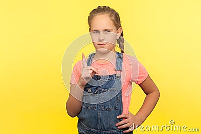 Be careful! Portrait of smart bossy little girl in denim overalls standing with admonishing gesture Stock Photo