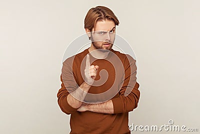 Be careful! Portrait of strict teacher, bossy man with beard wearing sweatshirt standing with admonishing gesture Stock Photo