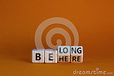 Be here belong symbol. Turned cubes and changed words `be here` to `belong`. Beautiful orange background. Business, belonging Stock Photo