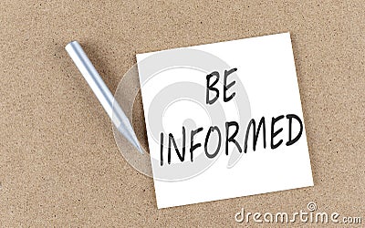 BE INFORMED text on sticky note on cork board with pencil Stock Photo