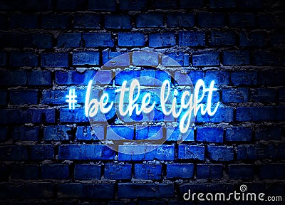 Be the light. Shining neon hashtag on blue brick wall background. Positive message Stock Photo