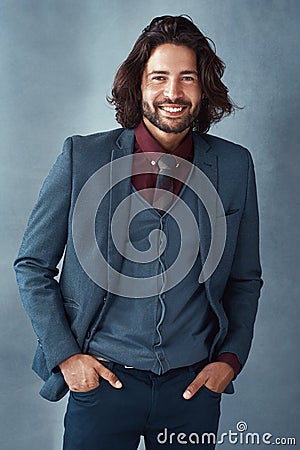 Be a man of substance and style. Studio shot of a handsome and dapper young man posing against a grey background. Stock Photo