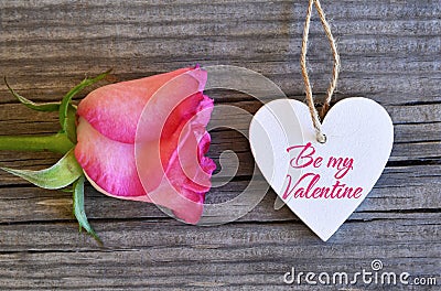 Be my Valentine.Valentines Day greeting card.Rose and decorative white heart on old wooden background.St.Valentine`s Day concept. Stock Photo