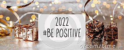 2022 be positive note with envelope, gifts and gold ribbon on white background Stock Photo