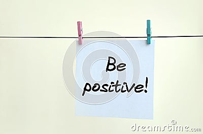 Be positive! Note is written on a white sticker that hangs with Stock Photo