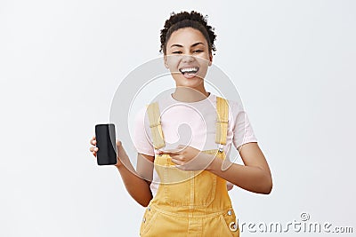 Be smart buy this device. Portrait of carefree happy African American female rejoicing, laughing out loud, wearing Stock Photo