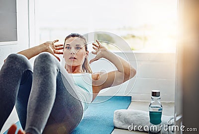 Always be a work in progress. a woman strengthening her core muscles. Stock Photo