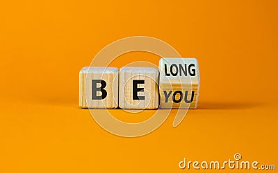 Be you, belong symbol. Turned a cube and changed words `be you` to `belong`. Beautiful orange background. Business, belonging Stock Photo