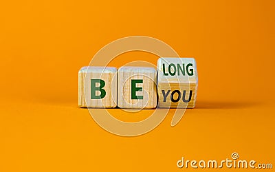 Be you, belong symbol. Turned a cube and changed words `be you` to `belong`. Beautiful orange background. Business, belonging Stock Photo