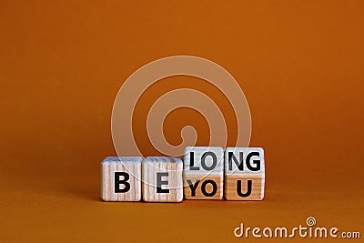 Be you, belong symbol. Turned cubes and changed words `be you` to `belong`. Beautiful orange background. Business, belonging a Stock Photo