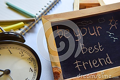 Be your best friend phrase colorful handwritten on chalkboard, alarm clock with motivation and education concepts. Stock Photo