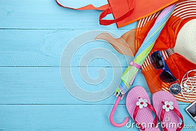 Beach accessory,hat,sunglasses,shoes,umbrella,beach lady hat,earphone,music player and compass on blue wooden background Stock Photo