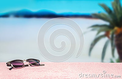 Beach background with free empty blank copy space. Trendy sunglasses on towel in beautiful paradise. Perfect lagoon beach. Stock Photo