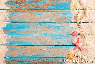 Op view of beach sand with shells, starfish on wood plank in blue sea Stock Photo