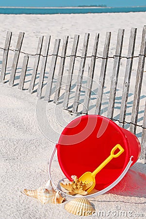 Beach bucket by fence Stock Photo