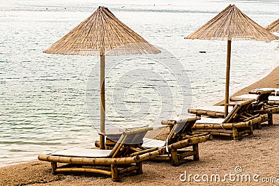 Beach chair and umbrella on sand beach. Concept for rest, relaxation, holidays, spa, resort Stock Photo