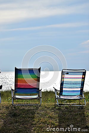Beach Chairs lined up on the side of the bay Stock Photo