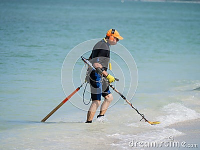 Beach comer with metal detector on the beach Editorial Stock Photo
