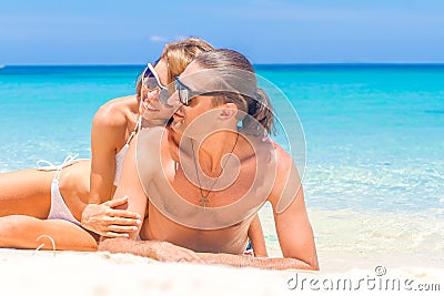 Beach couple looking. Happy young couple lying on sand under sun Stock Photo