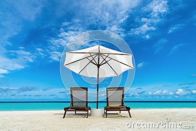 Beach lounger and umbrella on sand beach. Concept for rest, relaxation, holidays, spa, resort. Stock Photo