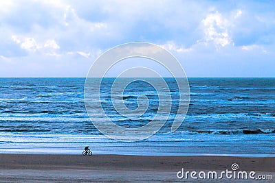 Beach of the northern sea in winter. A lone bicyclist Stock Photo