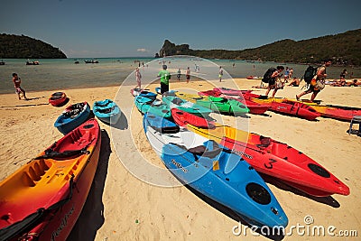 Beach on Phi Phi Island with lots of colorful boats and men with backpacks Editorial Stock Photo