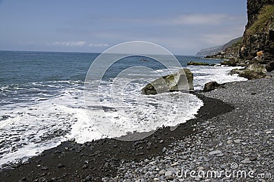 Beach Ponta de Sol pebble beach and rocky green coastline with cliffs, Madeira island Stock Photo