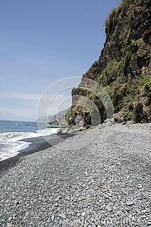 Beach Ponta de Sol pebble beach and rocky green coastline with cliffs, Madeira island Stock Photo