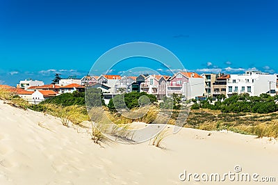 Beach sand dunes and colorful houses in a beach village Costa Nova, Portugal Stock Photo