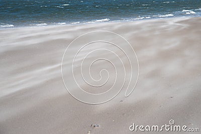 Beach with sand flying and sea. Can be used as background. Stock Photo