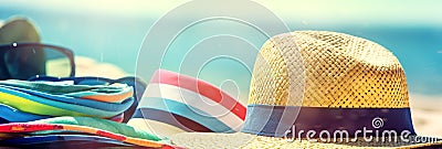 Beach straw hat and colorful clothes on sand on sea shore. Summer vacation concept. Created with generative Ai Stock Photo