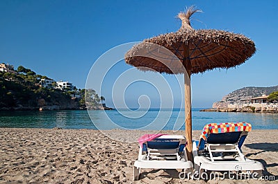 Beach sunbeds with towels and umbrella Stock Photo