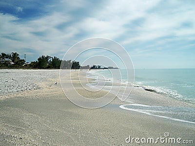 Beach on a sunny day with blue water. Stock Photo