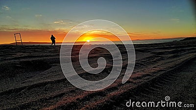 Beach sunset tracks sand sea silhouette Stock Photo