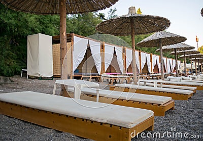 Beach to sea with sun beds and folded umbrellas Stock Photo