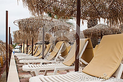 Beach umbrella and plastic deck chairs on the beach,Greek , pefkohori. Stock Photo