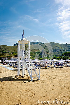Beach umbrellas, chaise lounge and Lifeguard tower on the sand beach of Sperlonga Stock Photo