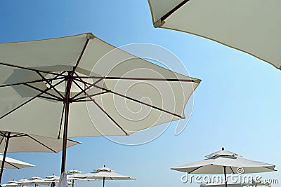 Beach umbrellas, large, white against the blue sky. Stock Photo