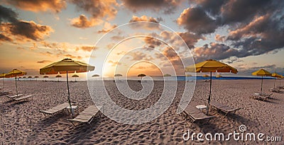 Beach with umbrellas and sun beds at sunset Stock Photo