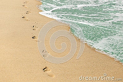 Beach, wave and footprints on sand. Vacation concept. Time, life passing Stock Photo